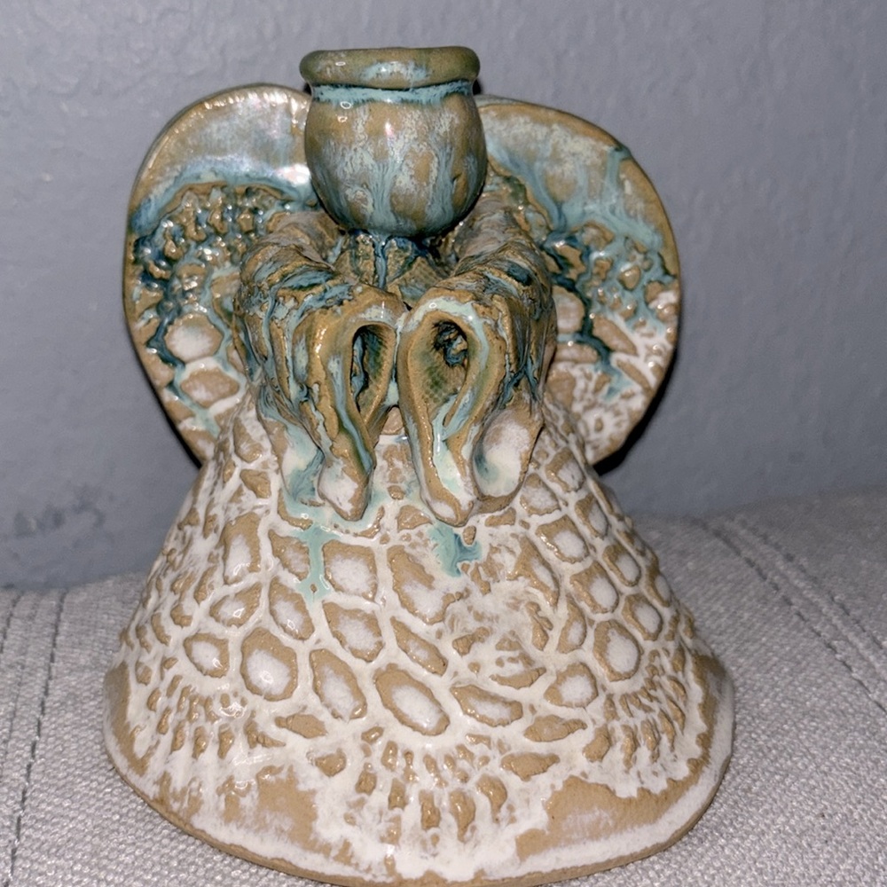 Handmade pottery angel figurine with a textured dress and wings.